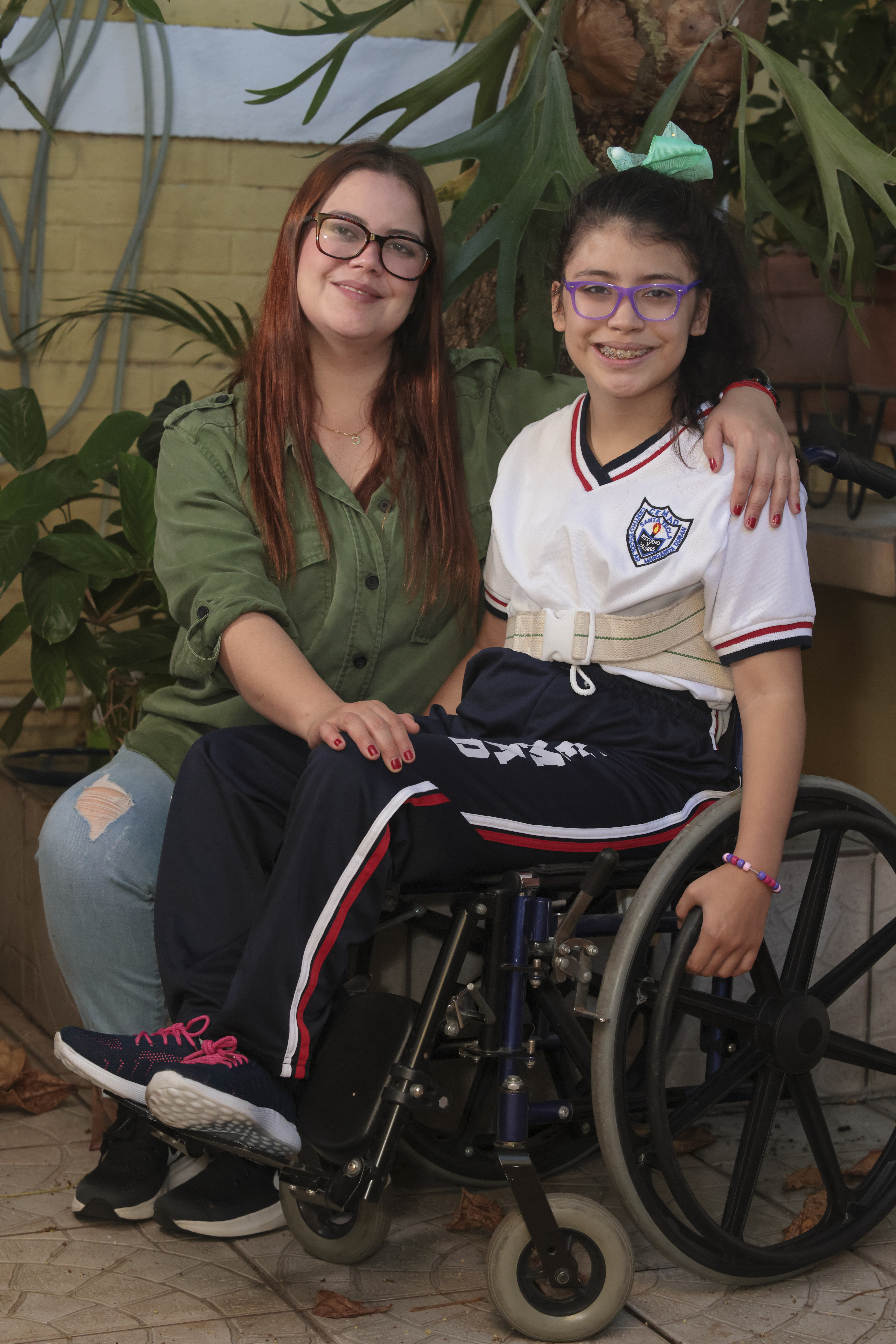 Madre con hija en silla de ruedas sonriendo