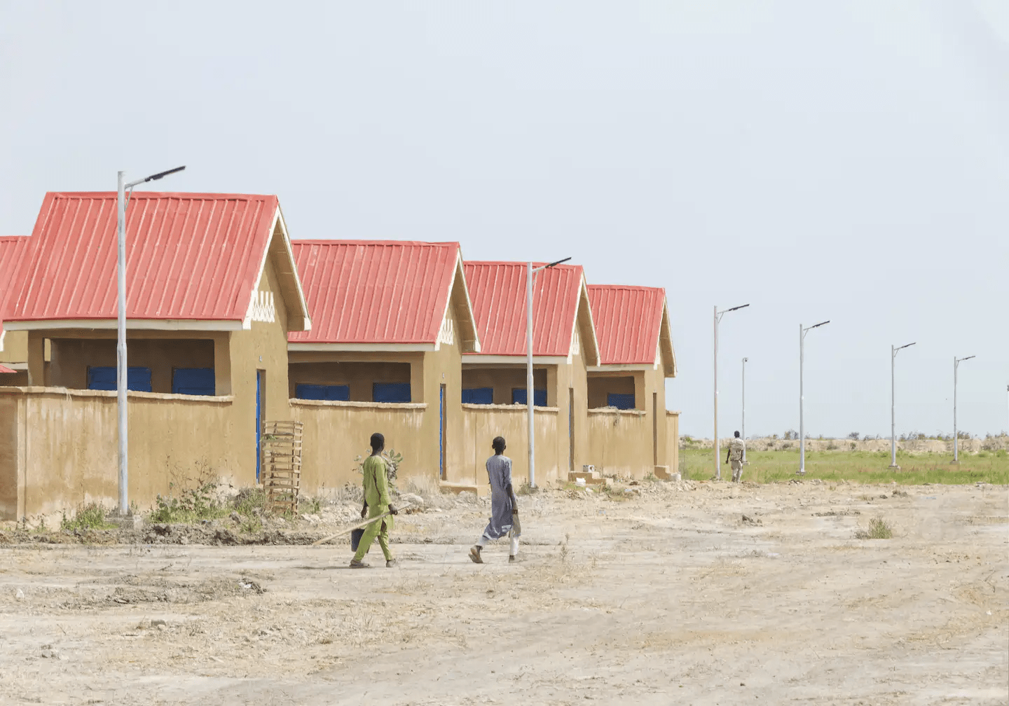 Two people walking in front a newly re-constructed village