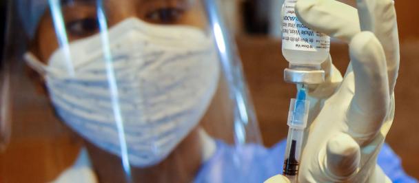 A health worker prepares a dose of COVID-19 vaccine at a vaccination centre in Refinery Community Hall in Guwahati, Assam, India, May 2021.
